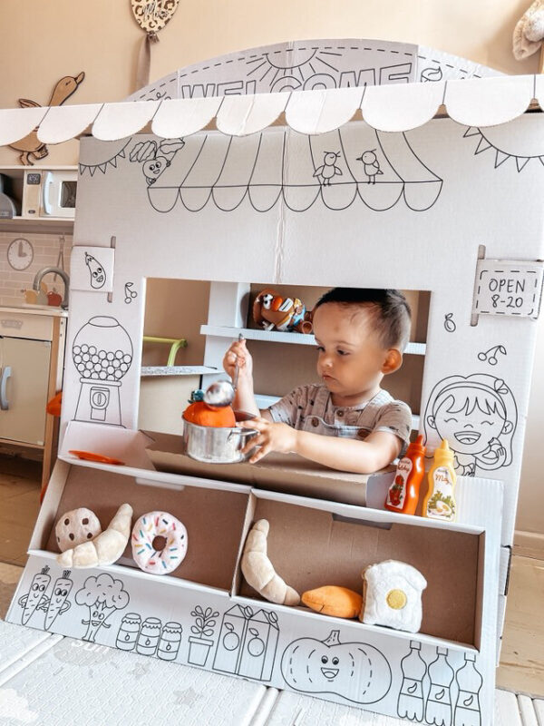 Bébé jouant au stand de marché en carton à colorier, jouet épicerie DIY, jeu de rôle enfant avec accessoires en feutre et plastique.