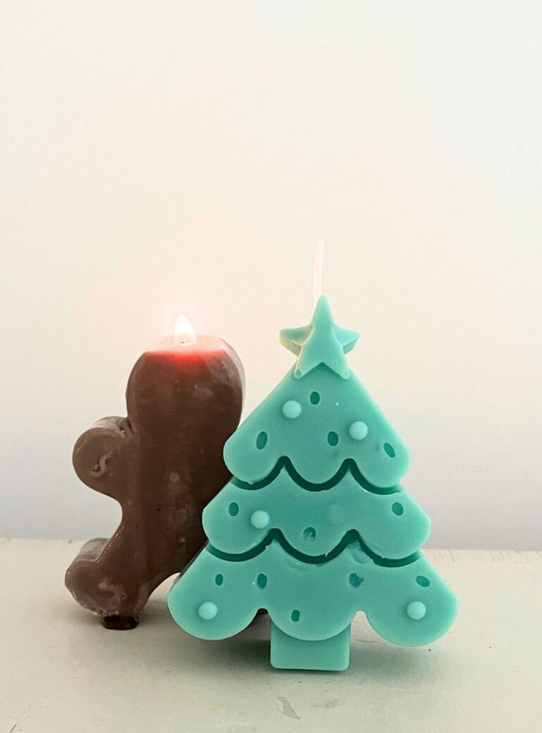Bougies artisanales de Noël : sapin vert menthe et bonhomme en pain d'épices allumé sur fond blanc.