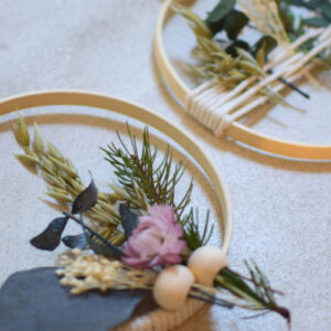 Décoration murale bohème en tambour à broder avec fleurs séchées, eucalyptus et perles en bois.