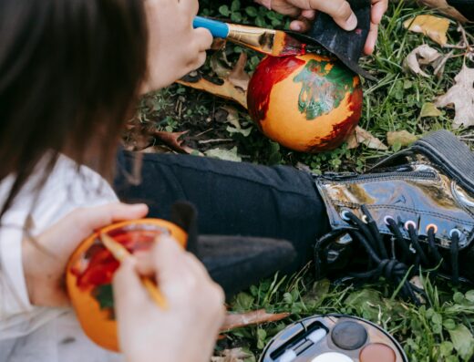 Enfants peignant des petites citrouilles d'Halloween dans l'herbe en automne